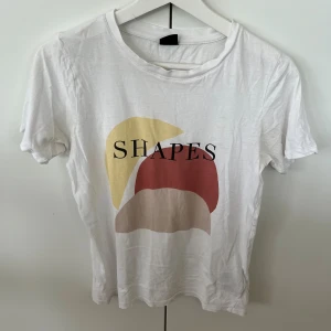 Vit T-shirt med tryck - Väldigt skön och basic t-shirt från Gina, ganska använt skick men inga fel på den. Mjuk och sitter perfekt.