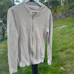 Full zip - Säljer denna feta Jack & Jones full zip i färgen beige! En deflekt på armen, men knappast använd!