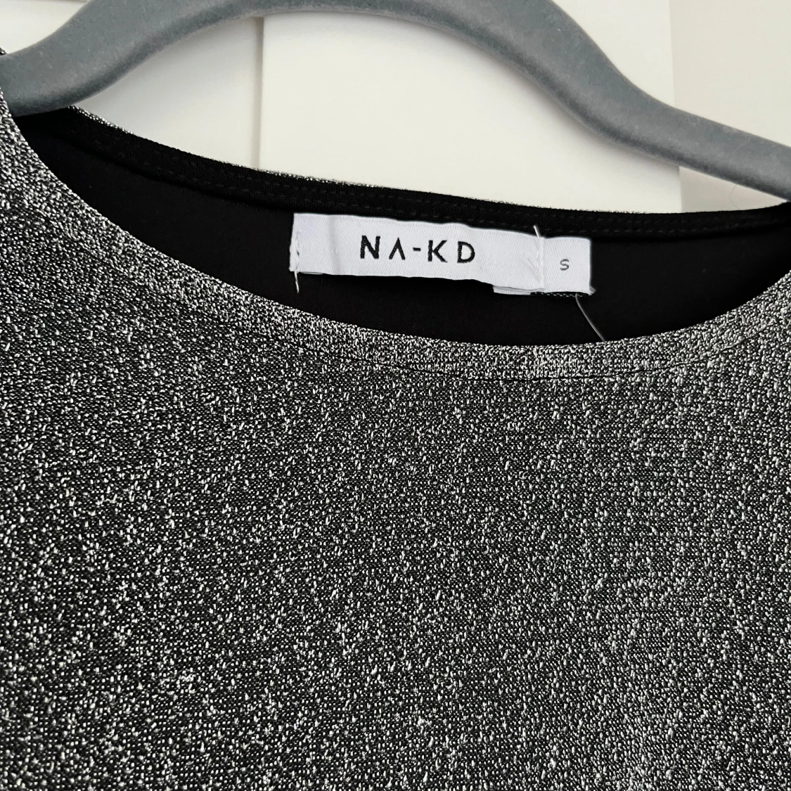 Glittrig topp med trumpetärm  - 90