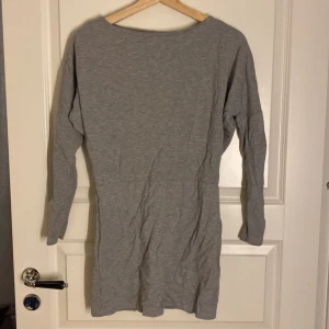 Grå klänning med öppen rygg - Snygg grå klänning med lång ärm och en stilren öppen rygg. 