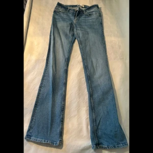Blå bootcut, low waist jeans från Bershka - Säljer ett par snygga blå bootcut jeans från Bershka i storlek XS. De är low waist och bootcut.  Nyskick. 🦋