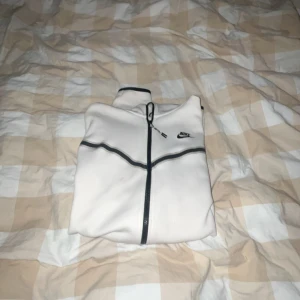 Vit Nike tech  - Hej! Jag säljer min vit Nike tech. Det är den första versionen av Nike tech med dom svarta sträcken. Den är näst intill o använd och väldigt bra skick Inge hål Inge defekter. 