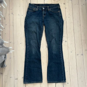 Levi's 545 jeans - Säljer ett par klassiska Levi's 545 jeans i mörkblå denim. De är lågmidjade och har en bootcut-stil och är i mycket bra skick. Midjemått: 39cm Innerbenslängd: 77cm