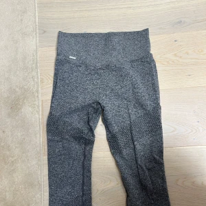 Grå leggings AIMN - Säljer ett par grå leggings i bra skick. De är högmidjade och har en tight passform, ett litet hål vid högra låret men designen är små hål så det syns ej. 