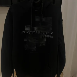 PLT Hoodie - En svart hoodie från PrettyLittleThing. 