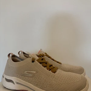 Beige sneakers från Skechers - Säljer ett par snygga och bekväma beige sneakers från Skechers. De har en stickad ovandel med snörning och en mjuk innersula för extra komfort. Perfekta för vardagsbruk eller lätt träning. Skorna är i mycket bra skick och redo för nya äventyr! Nästan inte alls använda. Jättefint skick. Nypris 1000 kr. 