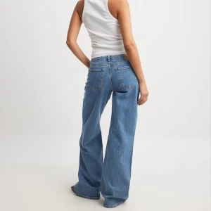 Blå jeans från NA-KD - MIDJA: 36 och INNERBENSLÄNGD: 81! Säljer ett par snygga blå jeans från NA-KD som är helt slutsålda på hemsidan. De är LÅGMIDJADE och har en avslappnad wide fit som ger en cool look. Perfekta för både vardag och fest! 🦋