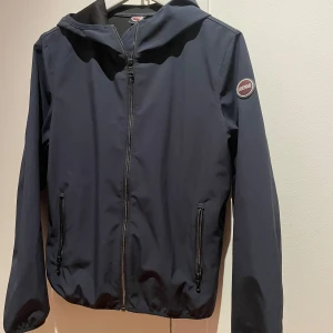 Mörkblå vindjacka från Colmar - Säljer nu en mörkblå vindjacka från colmar som är använd cirka 2 gånger. Det är storlek 166 (14y). Pris kan diskuteras. 