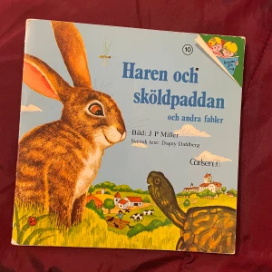 Haren och sköldpaddan och andra fabler - En charmig barnbok med illustrationer av J P Miller och svensk text av Dagny Dahlberg. Boken innehåller klassiska fabler som 'Haren och sköldpaddan' och 'Hunden och köttstycket', med färgglada och detaljerade bilder som förtydligar berättelserna.boken är från 1976