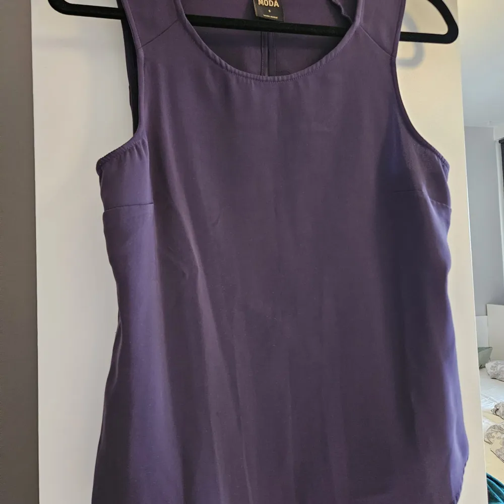Snygg lila ärmlös topp från Vero Moda i storlek S. Perfekt för sommardagar eller som ett lager under en kavaj. Toppen har en enkel och stilren design med rund halsringning.. Yläosat.