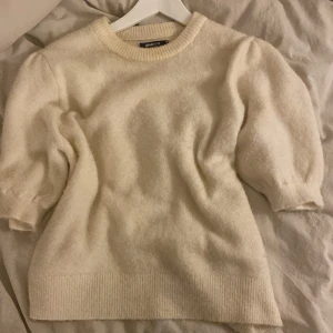 Vit tröja från Gina Tricot - Mysig vit tröja från Gina Tricot i storlek M. Perfekt för kyliga dagar med sin fluffiga och mjuka textur. Tröjan har en klassisk rund hals och trekvartsärmar som ger en stilren look. Passar både till vardags och lite finare tillfällen.