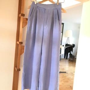 Blå byxor från Third Form - Säljer ett par snygga blå kostymbyxor från Third Form. De har en loose passform och är perfekta för både vardag och fest. Byxorna är högmidjade och har en stilren design med diskreta fickor bak. Färgen stämmer bäst överens med de två sista bilderna.