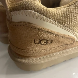 Beige sneakers från UGG - Säljer ett par snygga och bekväma UGG lowmell. Perfekta för höst och vinter med sin varma design. Skorna är helt oanvända säljer då dom kom i fel storlek❤️