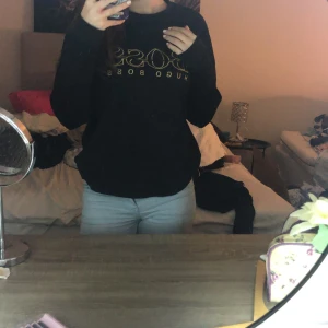 Svart tröja från Hugo Boss - Säljer en stilren svart tröja från Hugo Boss med guldtryck på bröstet. Tröjan har långa ärmar och en normal passform.Sliten på vissa ställen och pris kan diskuteras!❣️