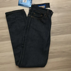 Mörkblå jeans från Acne Studios - Säljer ett par snygga mörkblå jeans från Acne Studios, Blå Konst-kollektionen. De är tillverkade i Italien och har en klassisk design med fem fickor och orange sömmar. Perfekta för både vardag och fest! 🖤