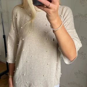 Stickad tröja med pärlor - Jättefin beige stickad tröja med vita pärlor från Zara. Jättefint skick. Kan mötas upp i Stockholm!