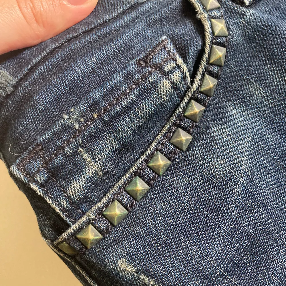 Säljer ett par snygga blå jeans från Levi's med nitar och slitningar på framsidan. De är i en klassisk blå färg och har låg midja. Vintage från 2008. Modell: 421 Skinny Jeans. Ok skick, slitning runt de påsydda slitningarna bara.. Jeans & Byxor.