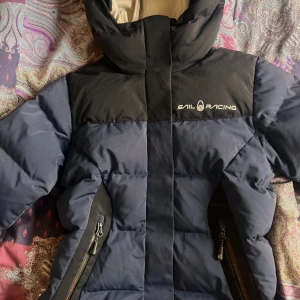 Jacka  - SailRacing jacka i storlek s, nästan som ny, använd i en halv vinter typ. Lite nopprig på insidan som synd på bilderna, och tre fläckar på insidan (se bild) som jag inte försökt ta bort än.