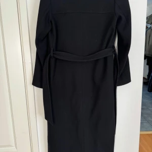 Lång Ullkappa - Säljer en svart lång ullkappa med inerfoder från Filippa k, den är i använt skick men inga defekter!  Ny pris är ca 4000 och jag säljer då den blivit för liten 