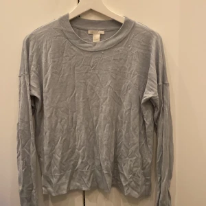 Ljusgrå tröja från Basic - Säljer en enkel och stilren ljusgrå tröja från Basic. Den är långärmad och har en rund halsringning med ribbade kanter. Perfekt för en avslappnad vardagslook. Tröjan är i bra skick och passar till det mesta i garderoben.