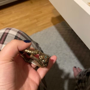 Cheetah armband - Guldigt armband som ser ut som en cheetah/leopard med gröna ögon. Inte äkta guld.