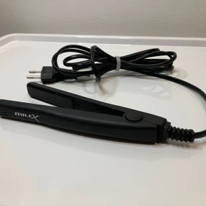 Plattång mini - Liten och smidig plattång som fungerar perfekt som reseplattång, men också för dig med kort hår eller lugg. Keramiska plattor ger bra värme och ergonomisk design med lampa som visar av/på.