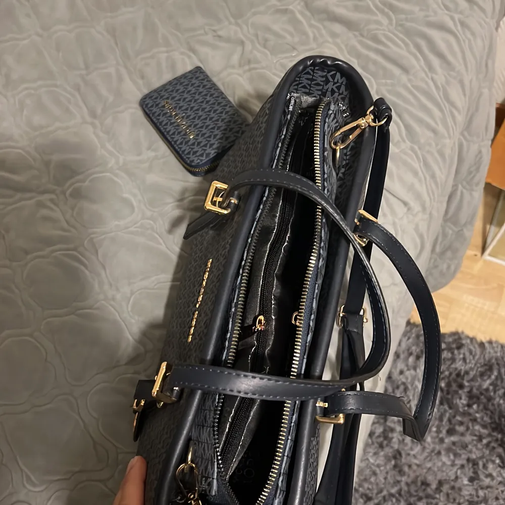 Den har både långa och korta band. Det finns en zip inuti väskan som rymmer massa samt en liten zip på sidan inuti väskan. Den har aldrig använts. Det tillkommer även en matchande plånbok. Den är fejk och är köpt i Turkiet. . Laukut & Käsilaukut.