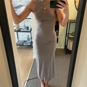 Snygg klänning med öppen rygg och slifs - Använd 1 gång, så väldigt fint skick! Normal i storleken