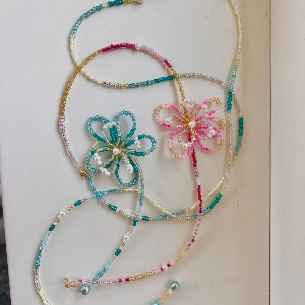 Intressekoll på pärlhalsband med blommor⭐️ Dessa två är dem första gjorde och dem kommer bara att bli bättre!! Man får själv välja färger och design, ex lång eller kort. Hör av er om ni är intresserade, priser mellan 200-350kr (kort eller lång)💕🙏🏻🫶🏻🤩. Accessoarer.