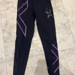 Träningstights - Svarta träningsbyxor/ tights med lila X från 2XU🌸 Jättebra skick. 