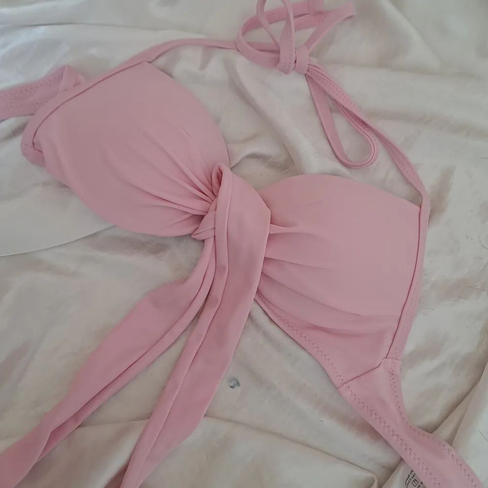 Säljer en superfin rosa bikiniöverdel i storlek XS. Den har en söt knytning framtill och är gjord av 82% polyester och 18% spandex, vilket gör den både bekväm och stretchig. Perfekt för sommarens alla badäventyr! 💖. Övrigt.