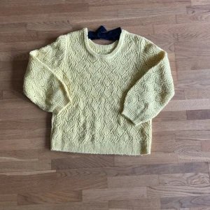 Gul stickad tröja med rosett i ryggen - Använd få gånger mycket bra skick 