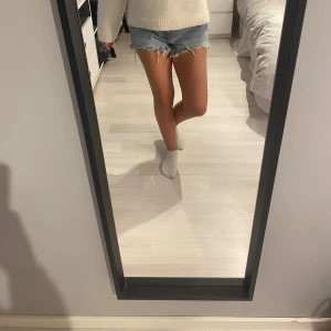 Blå jeansshorts från Zara - Säljer ett par snygga blå jeansshorts från Zara. De är i storlek EUR 36 och har en fräsch, avslappnad stil med råa kanter. 