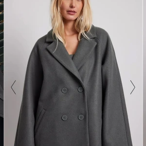 Nakd kappa - Höstkavaj/ kappa (tjock kavaj) superfin grå färg, jättefint skick - knappt använd.  Från Moa Mattsons kollektion med NA-KD strlk 38  Mått: ca 60 cm från axel till axel Ärm: ca 65 cm Hela kavajens längd: ca 85 cm