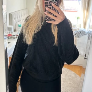 Svart stickad tröja - Säljer en svart stickad tröja som är supermysig och perfekt för kyligare dagar. Den har långa ärmar och en normal passform. Tröjan är i bra skick och passar till både vardag och fest. Perfekt att matcha med jeans eller kjol!