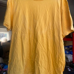 Gul t-shirt från Bik Bok - Säljer en solgul t-shirt från Bik Bok i storlek L. Den är perfekt för sommardagar med sitt mjuka bomullsmaterial och avslappnade passform. T-shirten har korta ärmar och en klassisk rund halsringning. Perfekt för en casual look! 🌞