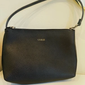 Guess- mini svart handväska  - Guess mini svart handväska med leopardprint på insidan. Endast använd ett fåtal gånger, utan synliga tecken på slitage.