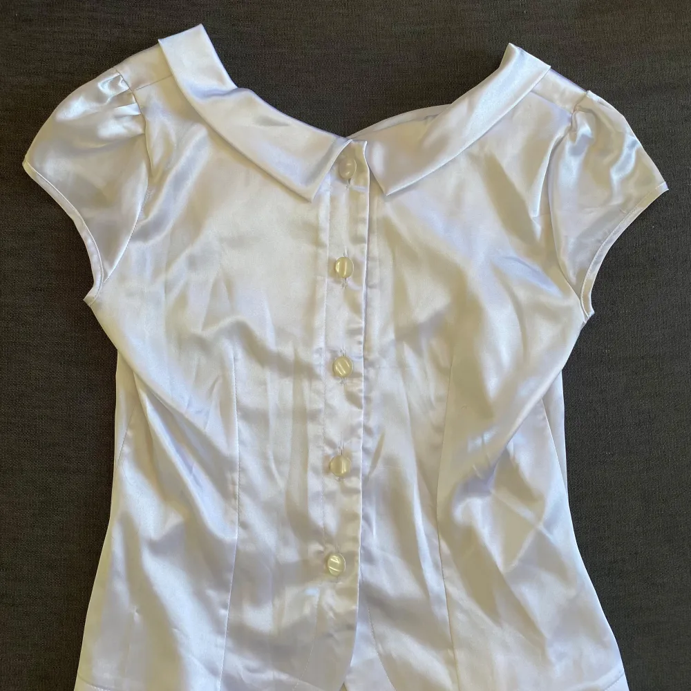 Vintage blouse i material som påminner om satin. Storlek 38/36 Man kan ha den åt båda hållen. Toppar.