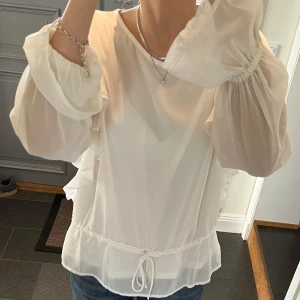 Vit blus med volanger  - Vit volangblus med snörning från Bik Bok i storlek M. Fint skick. Använd gärna köp nu! 
