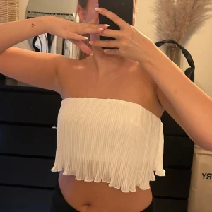 Vit topp - Säljer en vit topp med volanger. Inte genomskinlig och finns extra linne under som sitter bra så man kan vara utan bh men säker ändån. Man kan även bära den som bandå topp av att vika ner banden eller dom ett linne. Båda är super fint och sitter bra😍