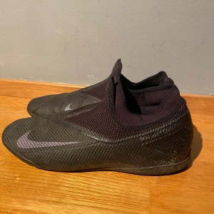 NIKE phantom vision 2 - svart  - Säljer ett par svarta fotbollsskor från Nike i bra skick. Skorna har en stilren design med diskret snörning. Kan användas som futsal (inomhus) och vanlig fotboll. Storlek 43-45 men är små i storleken.Skriv vid fler frågor! 