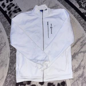 Vit zip up från sail racing - Säljer en vit jacka från Sail Racing i bra skick. Den har en dragkedja framtill och en liten bröstficka med dragkedja. Perfekt för vår och höst! Jackan är långärmad och har en stilren design.
