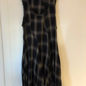 Countrystyle klänning - Säljer en superfin rutig klänning från Lindex i storlek L. Den har ett klassiskt rutmönster i mörka toner och är ärmlös, vilket gör den perfekt för både vår och höst. Klänningen har en lös passform, har fickor. Perfekt för en avslappnad dag eller en mysig fika med vänner! Kanske du dansar linedance?