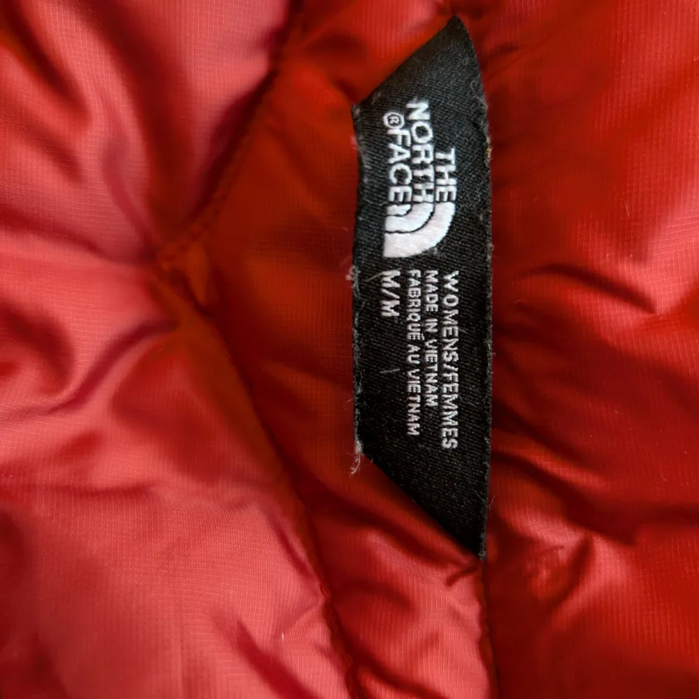 Säljer en snygg röd dunjacka från The North Face i mycket bra skick. Jackan har en dragkedja framtill och är perfekt för kyliga höst- och vinterdagar. Den är lätt och bekväm med en normal passform. Perfekt för dig som vill hålla värmen med stil! 🔥 Tecken på användning förekommer!. Jackor.