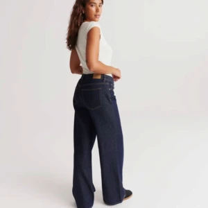 Mörkblå jeansbyxor - Snygga mörkblå jeansbyxor i loose fit med låg midja. Perfekta för en avslappnad stil, men kan också kläs upp för festligare tillfällen. De har en klassisk femficksdesign och stängs med dragkedja och knapp. Passar perfekt till både sneakers och klackar! Tyvärr är dem förkorta för min del, jag är 1.72. Orginal pris 499kr