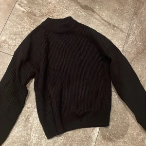 Svart stickad tröja från FB Sister - Säljer en svart stickad tröja från FB Sister i storlek XS. Tröjan har en ribbad design och en hög krage som håller dig varm under kyliga dagar. Perfekt för höst och vinter! 🖤