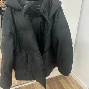 Svart pufferjacka från Vero Moda - Säljer en svart pufferjacka från Vero Moda i storlek EU 38. Jackan är perfekt för kalla dagar med sin vadderade design och har en dragkedja framtill. Den är i mycket bra skick och passar perfekt för vintern. Huvtröjan ger extra värme och stil. Perfekt för att hålla sig varm och snygg! 🖤