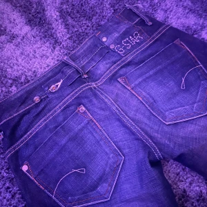 Mörkblå jeans från G-Star - Säljer ett par snygga mörkblå jeans från G-Star i bra skick. De har en cool slitning på benet. Passar till det mesta och är superbekväma! Jättebra skick och midjan går att tajta till på baksidan!😄skriv gärna om du har frågor💞