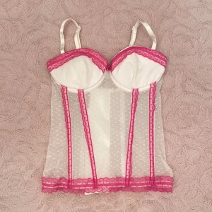 Vit & rosa spetskorsett🎀 - Supersöt vit korsett med rosa spetsdetaljer i gott skick. Den är prickig och är ganska transparent. Är inte säker på märket eller storlek men den passar säkert XXS och XS💖