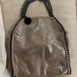 Glittrig axelväska från Stella McCartney - Säljer en superfin glittrig väska från Stella McCartney (liknande)! Super fint skick och superfin väska. Pris kan diskuteras❤️